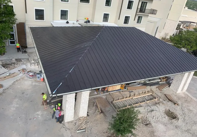 Metal roofing installation team working on a commercial building in Ettrick
